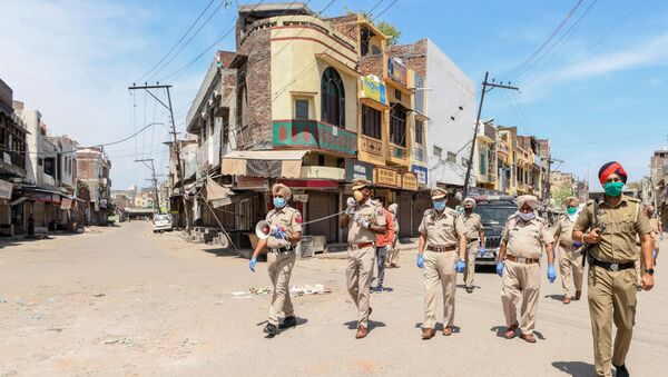 Punjab police personnel wearing facemasks patrol on a deserted street during a government-imposed nationwide lockdown as a preventive measure against the COVID-19 coronavirus, in Amritsar on April 11, 2020.  - Sputnik International