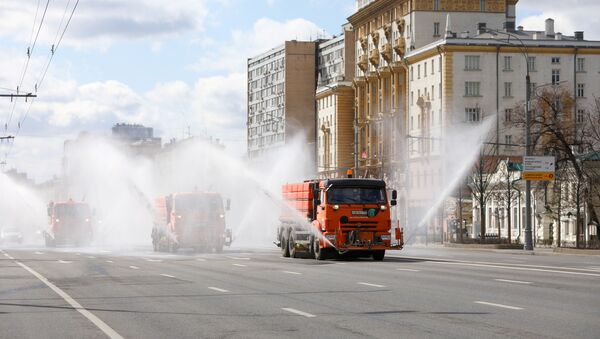 Vehicles drive near the U.S. embassy and spray disinfectant while sanitizing a road to prevent the spread of the coronavirus disease (COVID-19) in Moscow, Russia April 12, 2020 - Sputnik International