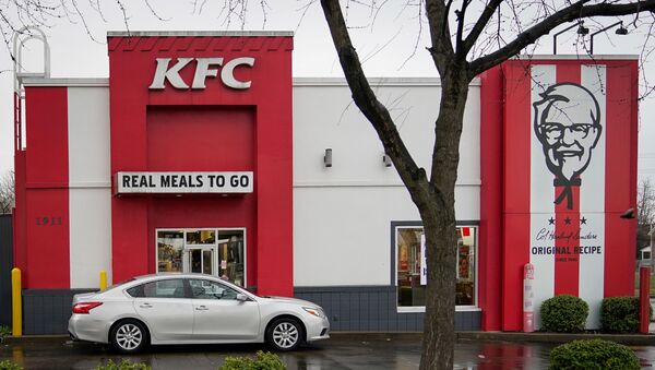 A vehicle waits at the drive-thru window of a Kentucky Fried Chicken (KFC) after a state mandated carry-out only policy went into effect in order to slow the spread of the novel coronavirus (COVID-19) in Louisville, Ky, U.S. March 24, 2020.  - Sputnik International