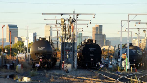 Oil tanker railcars are parked at a filling rack at sunrise with the Denver downtown skyline in the background October 14, 2014 - Sputnik International