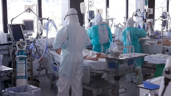Healthcare workers wearing protective suits attend to COVID-19 coronavirus patients in Barcelona - Sputnik International