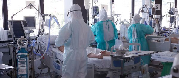 Healthcare workers wearing protective suits attend to COVID-19 coronavirus patients in Barcelona - Sputnik International
