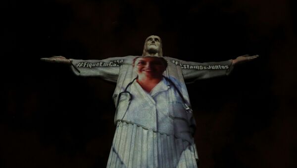 The statue of Christ the Redeemer is lit up with the image of a medical worker during an Easter Sunday event, amid the coronavirus disease (COVID-19) outbreak, in Rio de Janeiro, Brazil April 12, 2020 - Sputnik International