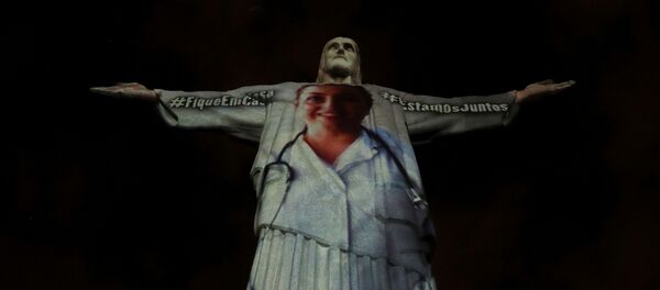 The statue of Christ the Redeemer is lit up with the image of a medical worker during an Easter Sunday event, amid the coronavirus disease (COVID-19) outbreak, in Rio de Janeiro, Brazil April 12, 2020 - Sputnik International