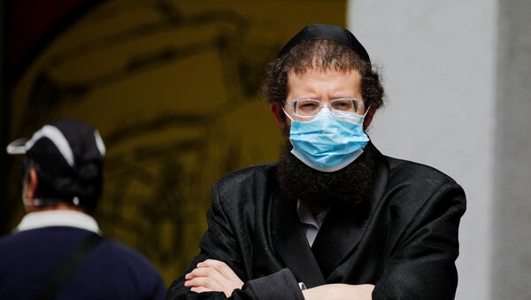 An ultra-Orthodox Jewish man wearing a mask looks on in Bnei Brak, a town badly affected by the coronavirus disease (COVID-19), and which Israel declared a restricted zone due to its high rate of infections, near Tel Aviv, Israel April 5, 2020 - Sputnik International