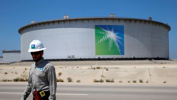 An Aramco employee walks near an oil tank at Saudi Aramco's Ras Tanura oil refinery and oil terminal in Saudi Arabia May 21, 2018 - Sputnik International