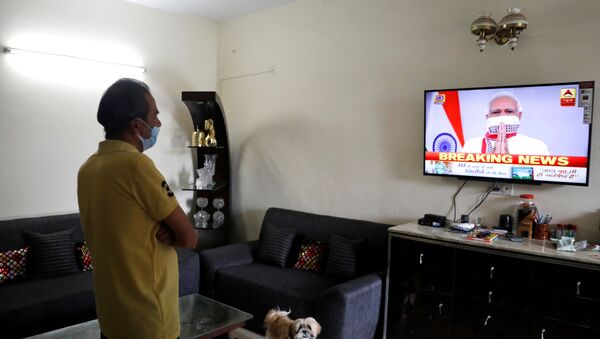 A man watches India's Prime Minister Narendra Modi's address to the nation on a television announcing the extension of a nationwide lockdown till May 3, to limit the spreading of coronavirus disease (COVID-19), in in New Delhi, India, April 14, 2020. REUTERS/Anushree Fadnavis - Sputnik International
