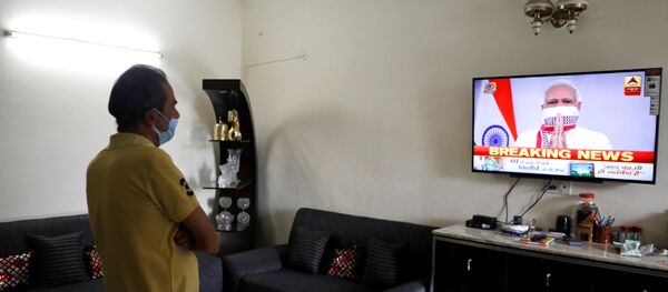A man watches India's Prime Minister Narendra Modi's address to the nation on a television announcing the extension of a nationwide lockdown till May 3, to limit the spreading of coronavirus disease (COVID-19), in in New Delhi, India, April 14, 2020. REUTERS/Anushree Fadnavis - Sputnik International