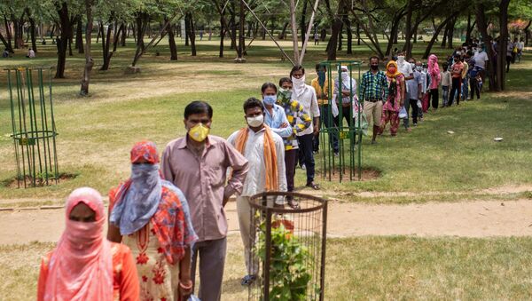 Residents stand in a queue for free food by government, during a nationwide lockdown to slow the spreading of the coronavirus disease (COVID-19), at a school in New Delhi, India, April 14, 2020 - Sputnik International