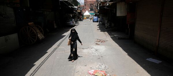 A woman walks on a deserted street during a nationwide lockdown to slow the spreading of the coronavirus disease (COVID-19) in the old quarters of Delhi, India, April 13, 2020 - Sputnik International