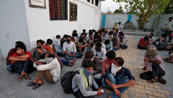 Migrant workers wait to be shifted to a shelter during a 21-day nationwide lockdown to slow the spreading of the coronavirus disease (COVID-19), in Ahmedabad, India, March 31, 2020.  - Sputnik International