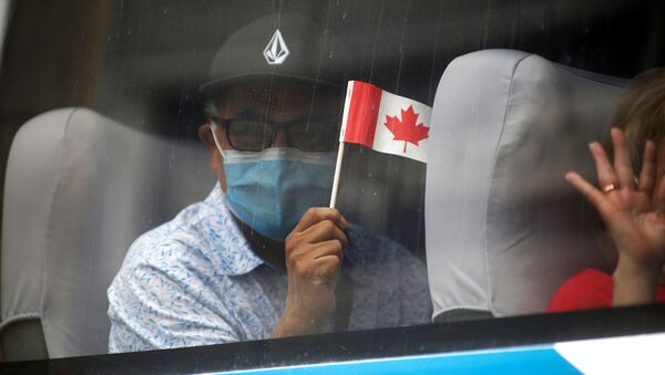 A man in a face mask waves a Canadian flag - Sputnik International