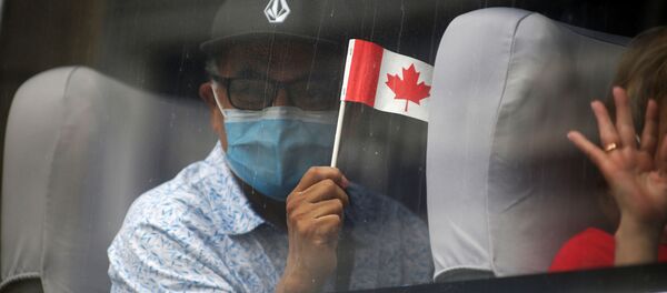 A man in a face mask waves a Canadian flag - Sputnik International