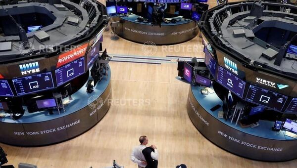 A trader puts on his jacket on the floor of the New York Stock Exchange (NYSE) as the building prepares to close indefinitely due to the coronavirus disease (COVID-19) outbreak in New York, U.S., March 20, 2020 - Sputnik International