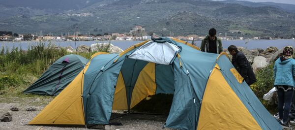 Migrants try to install a tent in the village of Petra on the northeastern Aegean island of Lesbos, Greece, Friday, 27 March 2020. Some 56 migrants who reached Lesbos in smugglers' boats from Turkey over the past few days have been quarantined in small tents in Petra for the past three days. Under public health measures adopted to hinder the spread of the new coronavirus, Greece places all people arriving from abroad in two-week quarantine. Lesbos' main migrant facility, near the village of Moria, is crammed with about 20,000 people even though it was built for 2,700. Migrants try to install a tent in the village of Petra on the northeastern Aegean island of Lesbos, Greece, Friday, 27 March 2020. Some 56 migrants who reached Lesbos in smugglers' boats from Turkey over the past few days have been quarantined in small tents in Petra for the past three days. Under public health measures adopted to hinder the spread of the new coronavirus, Greece places all people arriving from abroad in two-week quarantine. Lesbos' main migrant facility, near the village of Moria, is crammed with about 20,000 people even though it was built for 2,700. - Sputnik International