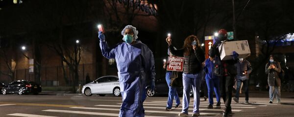 Nurses gather for a candlelight vigil to honor healthcare workers, during the outbreak of the coronavirus disease (COVID-19) at Lincoln Hospital in the Bronx borough of New York City, U.S., April 14, 2020 - Sputnik International