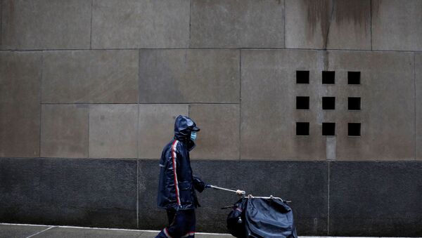 A United States Postal Service (USPS) worker works in the rain in Manhattan during the outbreak of the coronavirus disease (COVID-19) in New York City, New York, U.S., April 13, 2020 - Sputnik International
