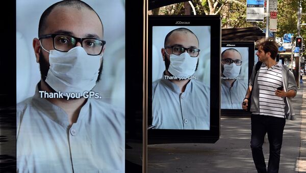 A man walks past bus stop advertising boards displaying thank you messages to health workers in response to the COVID-19 coronavirus outbreak, in Sydney on April 15, 2020 - Sputnik International