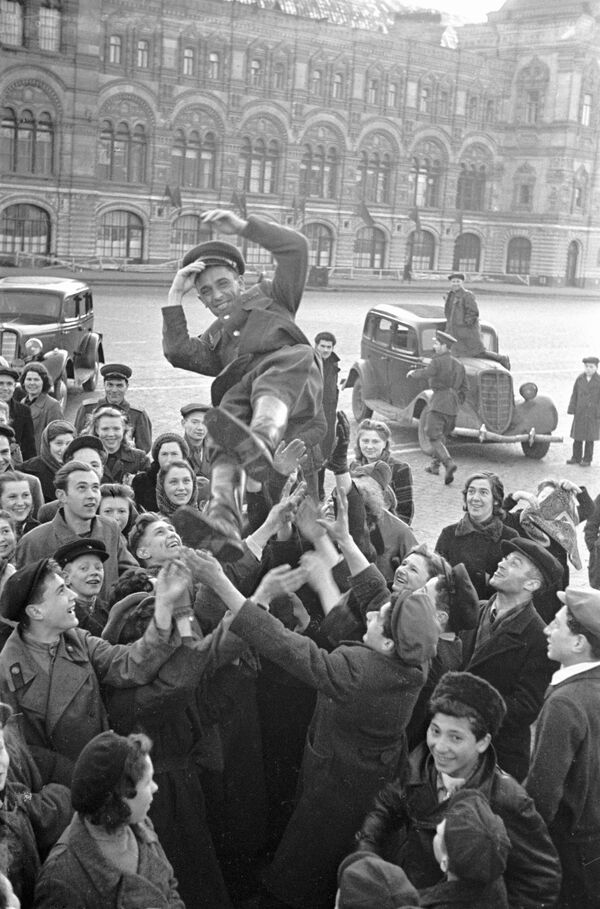 Muscovites are throwing an officer into the air as they celebrate Victory Day on 9 May 1945 on Red Square  - Sputnik International