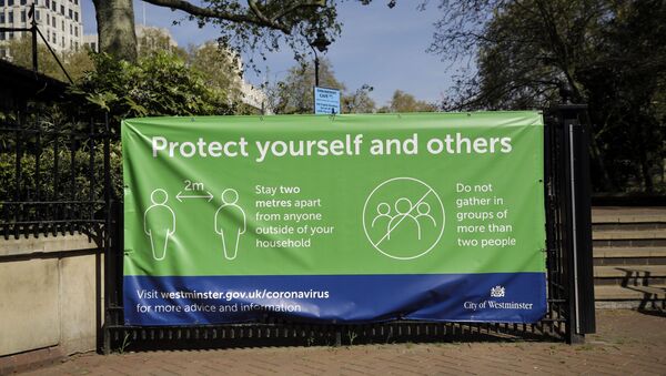 A coronavirus guidelines banner is displayed by an entrance to Victoria Embankment Gardens in London, during the lockdown to try and stop the spread of coronavirus, Wednesday, 15 April 2020.  - Sputnik International