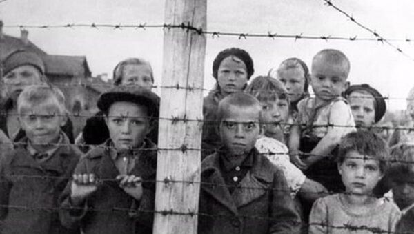 Staged photograph of Russian children at a formerly Finnish-run transfer camp in Petrozavodsk; photo taken by photographer Galina Sanko on 29 June 1944, one day after the Finns had left the area. The sign reads, in Finnish and Russian: Transfer camp. Entry to the camp and socializing through the fence are forbidden, violators will be shot - Sputnik International