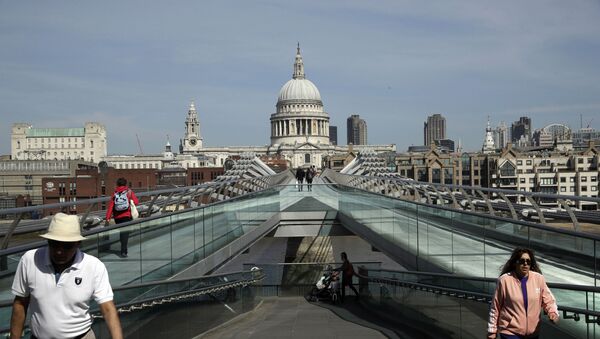 People space out to observe social distancing, on the Millennium Bridge backdropped by St Paul's Cathedral in London, during the lockdown to try and stop the spread of coronavirus, Wednesday, 15 April 2020. The British government is promising to test thousands of nursing home residents and staff for the new coronavirus, as it faces criticism for failing to count care-home deaths in its tally of victims. - Sputnik International