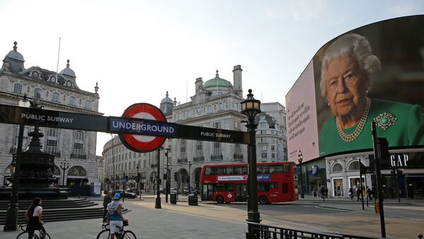 An image of Britain's Queen Elizabeth II making her her address to the UK and the Commonwealth in relation to the coronavirus epidemic is displayed on the advertising boards at Piccadilly Circus in central London on April 9, 2020, as Britain continues to battle the outbreak of Coronavirus Covid-19 and warm weather tests the nationwide lockdown as the long Easter weekend approaches. - The disease has struck at the heart of the British government, infected more than 60,000 people nationwide and killed over 7,000, with a daily death toll in England of 765 reported on April 9.  - Sputnik International