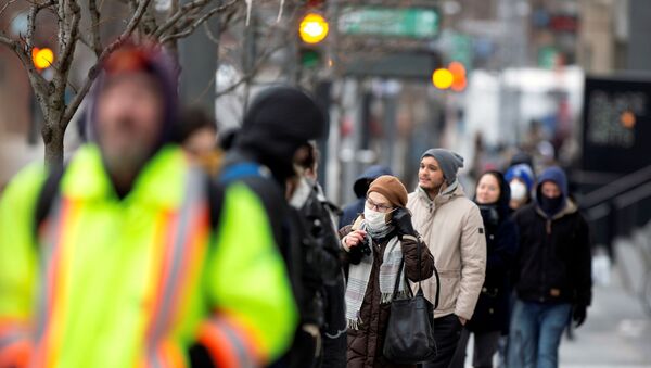 A woman adjusts her mask while she waits in line as the city's public health unit holds a walk-in clinic testing for coronavirus disease (COVID-19) in Montreal, Quebec, Canada March 23, 2020 - Sputnik International