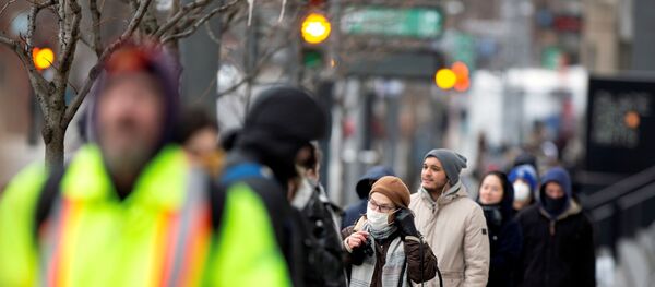 A woman adjusts her mask while she waits in line as the city's public health unit holds a walk-in clinic testing for coronavirus disease (COVID-19) in Montreal, Quebec, Canada March 23, 2020 - Sputnik International