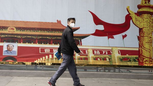 A resident wearing a mask against coronavirus walks past government propaganda poster featuring Tiananmen Gate in Wuhan in central China's Hubei province Thursday, April 16, 2020 - Sputnik International