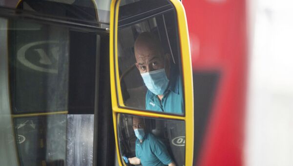 A London bus driver wearing a protective face mask, Wednesday 8 April 2020.  At least 14 transport workers in London have died from the COVID-19 coronavirus, prompting a new scheme forcing passengers to board buses using the middle doors to reduce contact with bus drivers.  The highly contagious COVID-19 coronavirus has impacted on nations around the globe, many imposing self isolation and exercising social distancing when people move from their homes. - Sputnik International