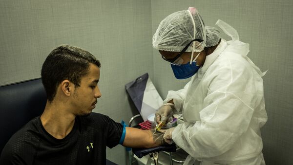 A nurse takes a blood sample, for testing for COVID-19, at a clinic in Rocinha favela, Rio de Janeiro, Brazil, on April 15, 2020. - Sputnik International
