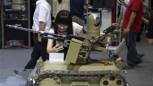 A visitor takes a photo of a remote-controlled weaponized robot on display at the 8th China International Exhibition on Police Equipment in Beijing, China, Thursday, May 19, 2016 - Sputnik International