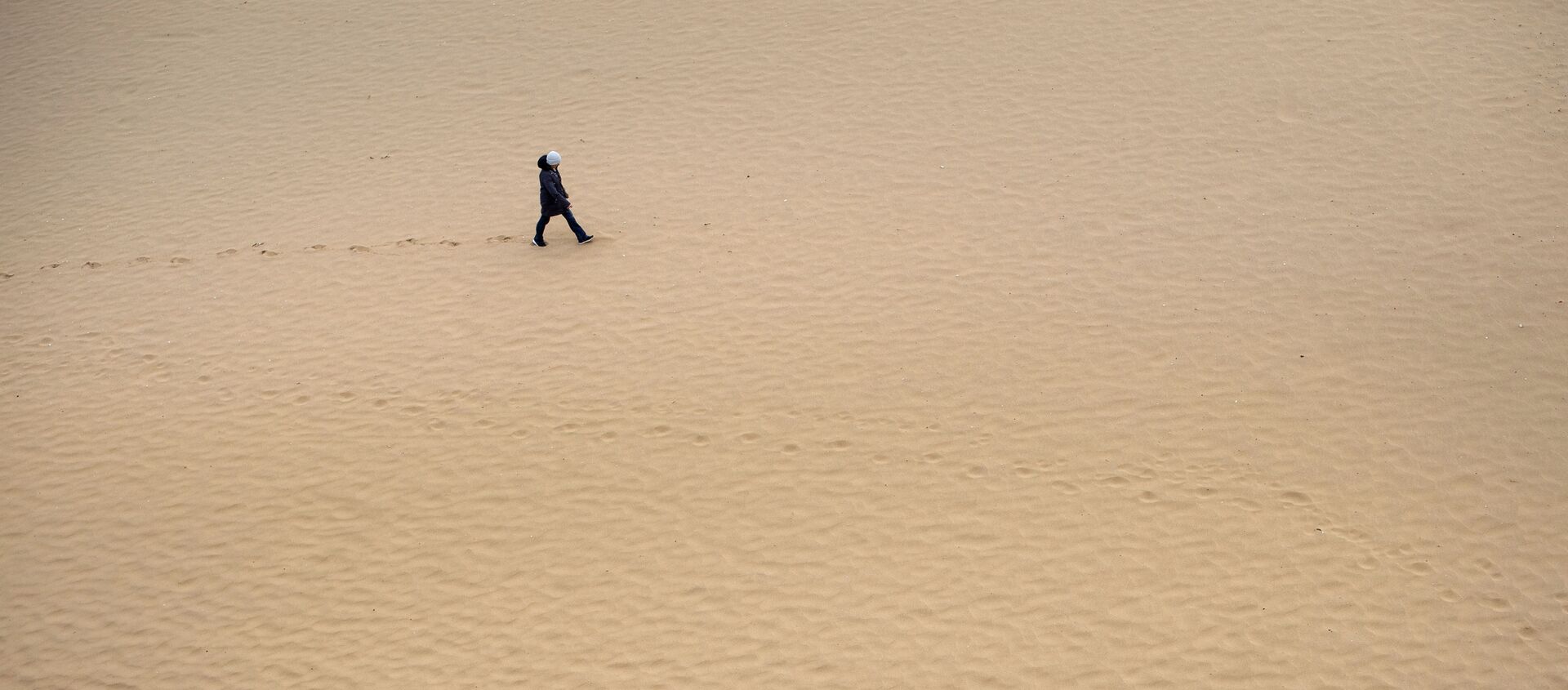 A solitary walker on the beach in Broadstairs, southern England, during the long Easter Bank Holiday as the UK continues in lockdown to help curb the spread of the coronavirus, Monday 13 April, 2020 - Sputnik International, 1920, 14.01.2021