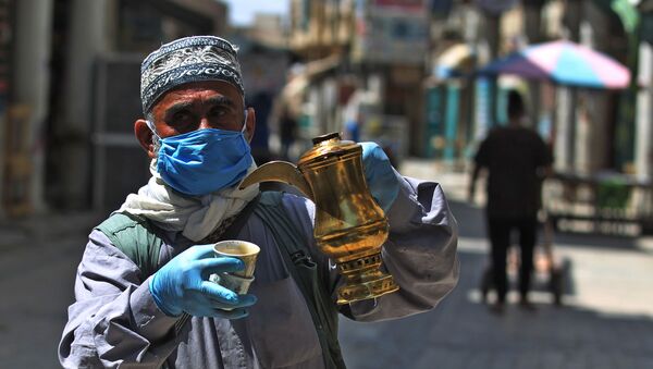 An Iraqi man sells coffee in the capital Baghdad's now deserted al-Mutanabbi street on April 17, 2020, known for its book sellers, during the novel coronavirus pandemic crisis that urged authorities to shut down social gathering places in a bid to slow its spread among the population.  - Sputnik International