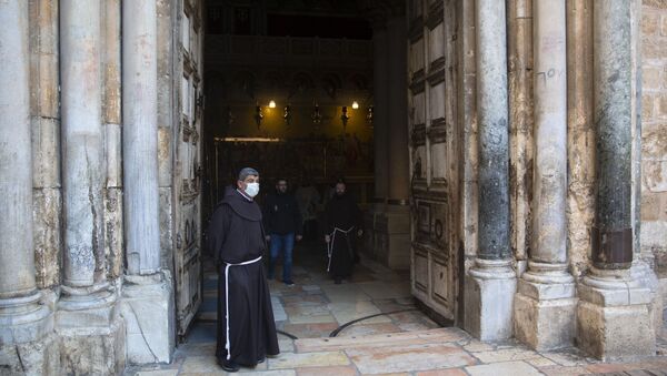 A Christian clergyman waits for the Easter Sunday Mass at the Church of the Holy Sepulchre, believed by many Christians to be the site of the crucifixion and burial of Jesus Christ, in Jerusalem's old city, Sunday, April 12, 2020.  - Sputnik International