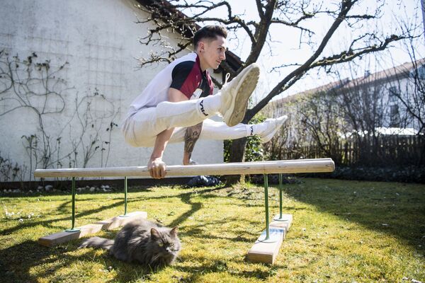 Marcel Nguyen, artistic gymnast, trains on a training bar in his mother's garden in Unterhaching, Germany,  25 March 2020 - Sputnik International