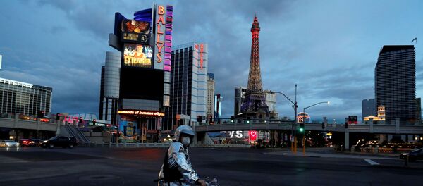 A man stands on his bicycle  on the Las Vegas strip as the spread of coronavirus disease (COVID-19) continues, in Las Vegas, Nevada U.S., April 10, 2020. - Sputnik International