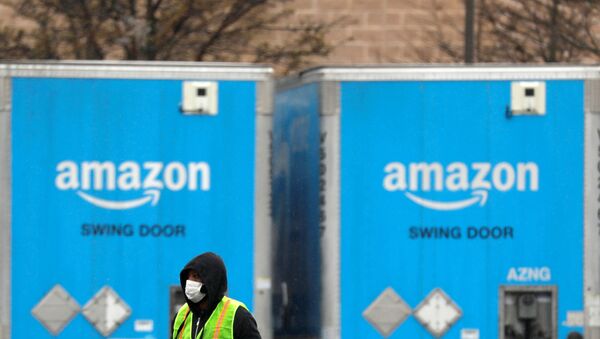 A worker in a face mask walks by trucks parked at an Amazon facility as the global coronavirus outbreak continued in Bethpage on Long Island in New York, U.S., March 17, 2020 - Sputnik International