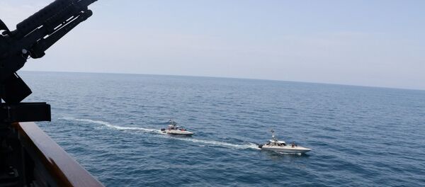 Two Iranian Islamic Revolutionary Guard Corps Navy (IRGCN) vessels, some of several to maneuver in what the U.S. Navy says are unsafe and unprofessional actions against U.S. Military ships by crossing the ships’ bows and sterns at close range is seen next to the guided-missile destroyer USS Paul Hamilton in the Gulf April 15, 2020 - Sputnik International