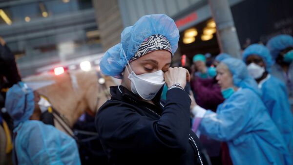 A nurse wipes away tears as she stands outside NYU Langone Medical Center on 1st Avenue in Manhattan as New York Police Department (NYPD) Mounted Police and other units came to cheer and thank healthcare workers at 7pm during the outbreak of the coronavirus disease (COVID-19) in New York City, New York, U.S., April 16, 2020.  - Sputnik International
