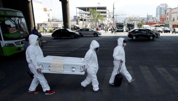 Activists wearing protective suits carry a coffin with a banner attached that says Nuevo Leon locked up or buried as part of an awareness campaign, amid the spread of the coronavirus disease (COVID-19), in Monterrey, Mexico - Sputnik International