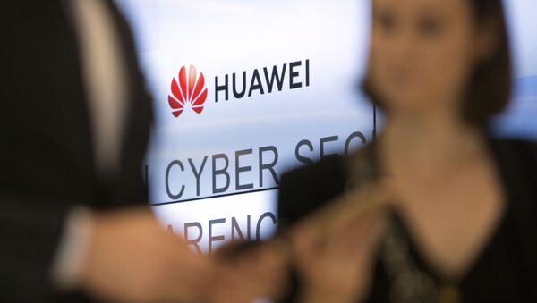 Two people look at their cellphones in front of the Huawei logo during a DigitALL lunch talk in Brussels, Tuesday, May 21, 2019 - Sputnik International