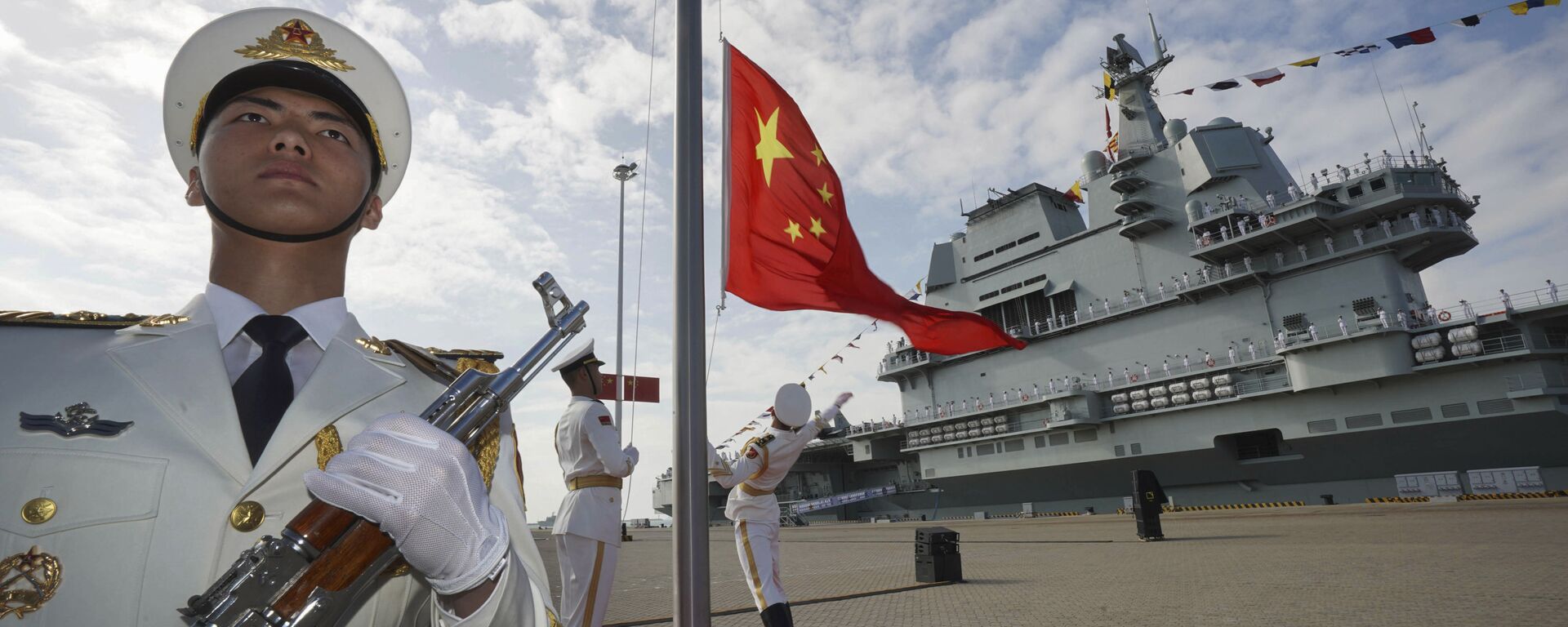 In this photo taken Dec. 17, 2019 and released Dec. 27, 2019 by Xinhua News Agency, Chinese honor guard raise the Chinese flag during the commissioning ceremony of China's Shandong aircraft carrier at a naval port in Sanya, south China's Hainan Province - Sputnik International, 1920, 16.09.2021