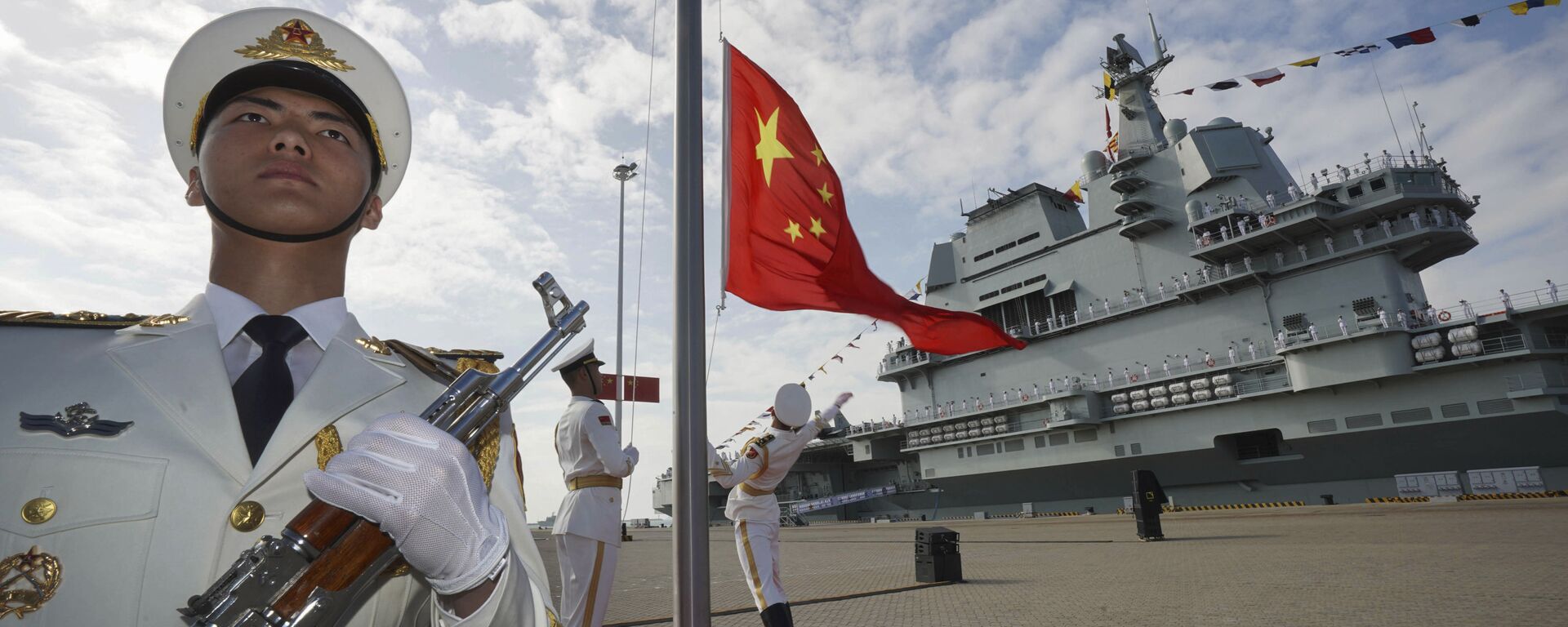 In this photo taken Dec. 17, 2019 and released Dec. 27, 2019 by Xinhua News Agency, Chinese honor guard raise the Chinese flag during the commissioning ceremony of China's Shandong aircraft carrier at a naval port in Sanya, south China's Hainan Province - Sputnik International, 1920, 25.10.2023