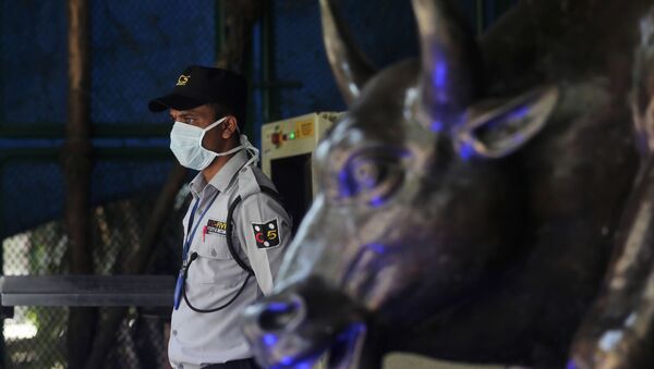 A security guard wearing a mask as a precaution against the new coronavirus stands at the Bombay Stock Exchange (BSE) building in Mumbai, India, Monday, 16 March 2020 - Sputnik International
