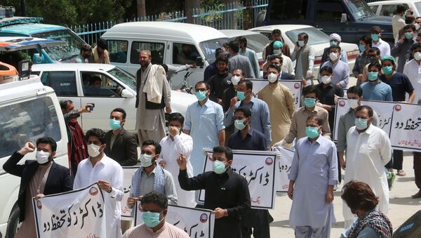 FILE PHOTO: Doctors wearing face masks chant slogans during a protest against the lack of protective gears for medical staff who are treating coronavirus disease (COVID-19) patients in Quetta, Pakistan April 6, 2020 - Sputnik International