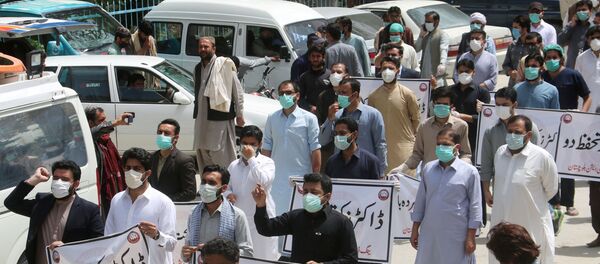 FILE PHOTO: Doctors wearing face masks chant slogans during a protest against the lack of protective gears for medical staff who are treating coronavirus disease (COVID-19) patients in Quetta, Pakistan April 6, 2020 - Sputnik International