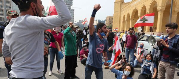 Anti-government demonstrators wearing face masks gesture as they protest during a countrywide lockdown to combat the spread of the coronavirus disease (COVID-19), in Beirut, Lebanon April 21, 2020 - Sputnik International