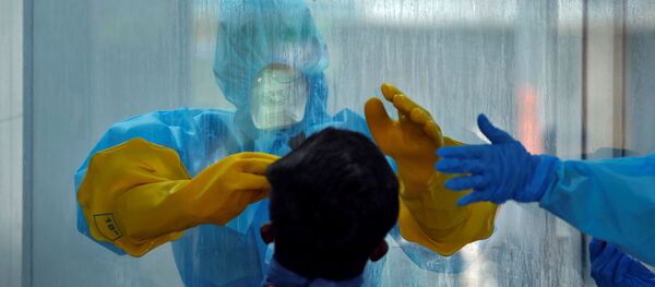A doctor in a protective chamber takes a swab from a man to test for coronavirus disease (COVID-19) in India - Sputnik International
